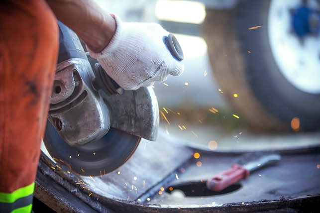 Smedevikar i fuld gang med arbejdet - svejsning af maskine