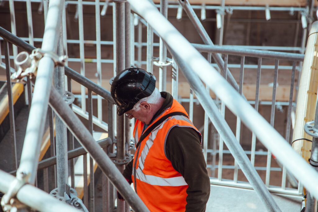 Bygherre på inspektion på byggepladsen i orange sikkerhedsvest